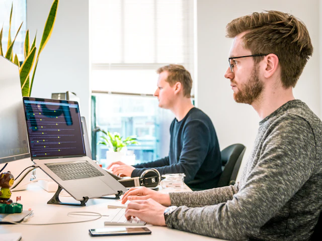 A developer at a desk working on a large monitor